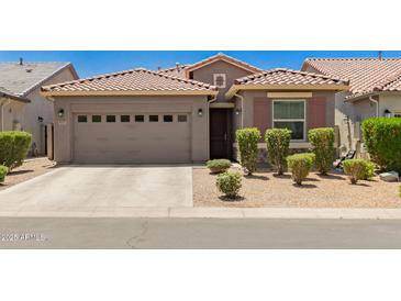 Charming single-story home featuring a two-car garage and meticulously maintained front yard at 9535 E Tupelo Ave, Mesa, AZ 85212