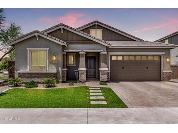 Charming single-story home with well-manicured lawn, brick accents, and a two-car garage at 1026 N 152Nd Ave, Goodyear, AZ 85338