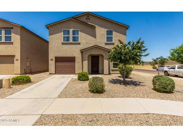 Inviting two-story home featuring a well-maintained yard and a one car attached garage at 198 E Patton Ave, Coolidge, AZ 85128