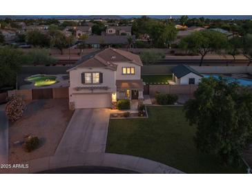Inviting two-story home featuring a well-manicured lawn, attached garage, and private backyard pool, perfect for outdoor entertainment at 2661 E Los Alamos Ct, Gilbert, AZ 85295