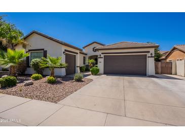 Charming single-story home featuring a three-car garage, desert landscaping, and a neutral color palette at 3971 E Leo Pl, Chandler, AZ 85249