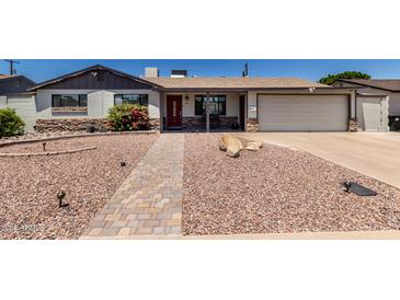 Charming single-story home featuring rock landscaping and a brick walkway to the inviting red front door at 6838 E Belleview St, Scottsdale, AZ 85257
