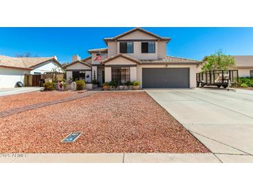 Charming two-story home with a well-manicured front yard, and a two car garage at 7749 W Hearn Rd, Peoria, AZ 85381