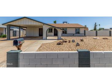 Charming single-story home with a covered carport, xeriscaped yard and painted decorative block wall at 9801 N 56Th Dr, Glendale, AZ 85302