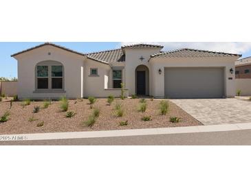 Stunning home exterior featuring a paver driveway and low-maintenance desert landscaping at 21541 W Mariposa St, Buckeye, AZ 85396