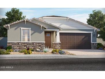 Charming single-story home featuring stone accents, a two-car garage, and professionally landscaped front yard at 24448 W Grenadine Rd, Buckeye, AZ 85326