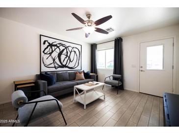 Stylish living room features a gray sofa, accent chairs, and modern art at 6012 W Flower St, Phoenix, AZ 85033