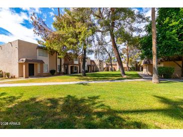 Charming townhomes with lush green lawn and mature trees create a serene and inviting community atmosphere at 7126 N 19Th Ave # 224, Phoenix, AZ 85021