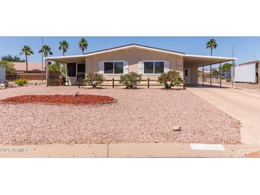 Inviting single-story home featuring a charming front yard and covered parking at 8730 E Dewan Ave, Mesa, AZ 85208