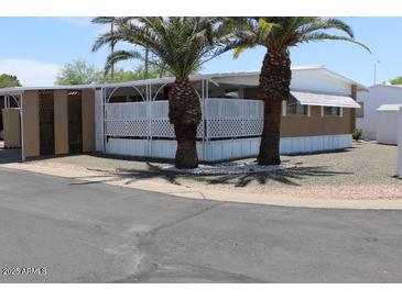 Cozy home featuring mature palm trees and a charming lattice-enclosed porch area at 9501 E Broadway Rd # 254, Mesa, AZ 85208