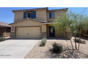 Charming two-story home featuring desert landscaping, a two-car garage, and a well-manicured lawn at 1091 W West Virginia Ave, Florence, AZ 85132
