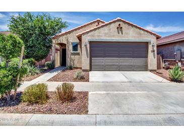 Charming single-Gathering home featuring a neutral-toned facade, low maintenance landscape, and an attached two-car garage at 14160 W Georgia Dr, Surprise, AZ 85379