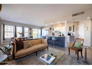 Inviting living room with stylish sofa, open floor plan, and modern kitchen with breakfast bar at 2201 N Central Ave # 3C, Phoenix, AZ 85004
