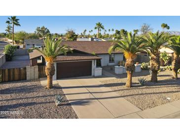 Charming single-story home with desert landscaping, mature palm trees, and a spacious two-car garage at 5802 E Spring Rd, Scottsdale, AZ 85254