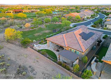 Spacious backyard with a covered patio, outdoor kitchen, fire pit and mountain views at 13236 W Montansoro Ln, Peoria, AZ 85383