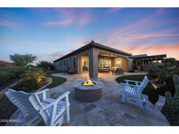 Outdoor living space with travertine patio, fire pit, seating and built-in grill at 13236 W Montansoro Ln, Peoria, AZ 85383