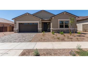 Charming single-story home featuring a two-car garage and desert landscaping at 15833 W Bronco Trl, Surprise, AZ 85387