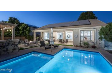 Inviting backyard with pool, lounge area, and fire pit offers a perfect space for relaxation and entertainment at 3237 E Park Ave, Gilbert, AZ 85234
