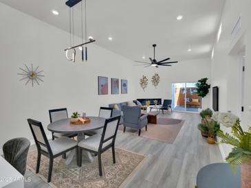 Bright, open-concept living room and dining area with modern decor and sliding doors to the patio at 3401 N 37Th St # 14, Phoenix, AZ 85018