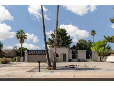 Stunning single-story home featuring desert landscaping, palm trees, and modern architectural details at 5341 E Sheena Dr, Scottsdale, AZ 85254