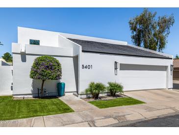 Front exterior view of modern home showing a xeriscaped front yard and white stucco exterior at 5401 N 25Th St, Phoenix, AZ 85016