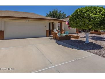 Charming single-story home featuring an attached two-car garage, brick accents, and a welcoming front patio at 8160 E Keats Ave # 364, Mesa, AZ 85209
