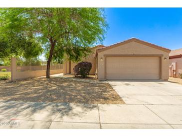 Charming single-story home featuring a two-car garage and a well-maintained front yard with desert landscaping at 8321 W Hughes Dr, Tolleson, AZ 85353