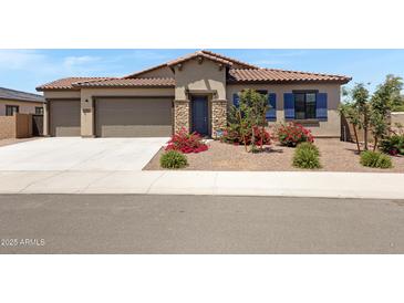 Charming home with a two-car garage, beautiful stone accents, and professionally landscaped front yard at 8350 W Carole Ln, Glendale, AZ 85305
