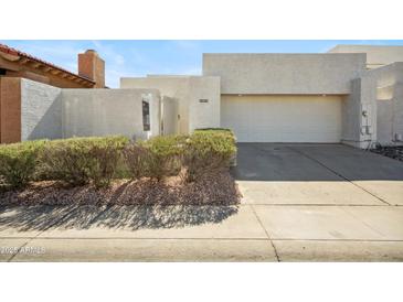 Contemporary home with a two-car garage, stucco exterior, and desert landscaping at 11079 N 110Th Pl, Scottsdale, AZ 85259