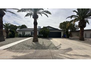 Charming single-story home with desert landscaping, mature palm trees, and a two-car garage at 11250 N 33Rd Ave, Phoenix, AZ 85029