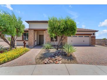Charming single-story home with stone accents, a well-manicured yard, and a two-car garage at 17179 S 174Th S Dr, Goodyear, AZ 85338