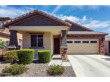 Charming single-story home with a two-car garage, stone accents, and well-maintained landscaping in front at 18808 W Solano Dr, Litchfield Park, AZ 85340