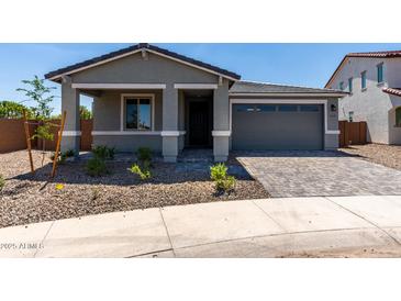 Inviting single-Gathering home featuring a well-manicured lawn and an attached two-car garage and a paver driveway at 21348 N Belt Dr, Maricopa, AZ 85138