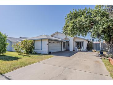 Charming single-story home with a well-manicured lawn and mature trees, showcasing its inviting curb appeal at 2202 W Enid Ave, Mesa, AZ 85202