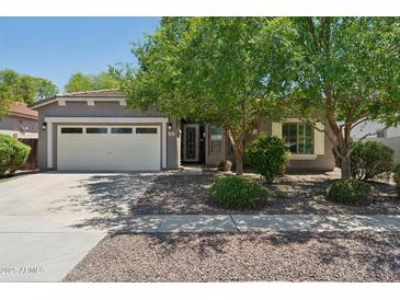 Charming single-story home with a two-car garage and mature shade trees in a well-maintained front yard at 2957 E Melrose St, Gilbert, AZ 85297