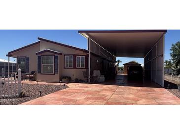 Inviting single-story home featuring a large covered patio and a spacious driveway for parking at 316 S 74Th Way, Mesa, AZ 85208