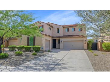 Inviting two-story home featuring a three-car garage, desert landscaping, and a classic tile roof at 3813 W Lapenna Dr, New River, AZ 85087