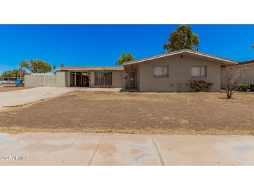 Charming single story home with a front yard and covered parking at 5738 W Heatherbrae Dr, Phoenix, AZ 85031