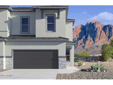 Modern two-story home with a gray garage door, stone accents, and mountain views at 5844 E Covey Ln, Phoenix, AZ 85054