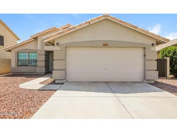 Charming single-story home with a well-maintained front yard, featuring a two car garage and desert landscaping at 6875 W Townley Ave, Peoria, AZ 85345