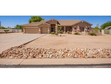 Charming single-story home featuring a well-maintained desert landscape, a three-car garage, and a welcoming entrance at 9658 W Golddust Dr, Queen Creek, AZ 85144