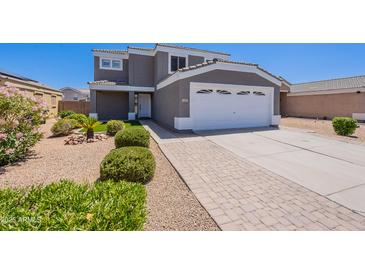 Charming two-story home with landscaped front yard, paved driveway, and a two-car garage at 12801 W Sweetwater Ave, El Mirage, AZ 85335