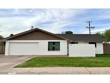 Charming single-story home with a white exterior, attached garage, and well-maintained lawn at 228 E Del Rio Dr, Tempe, AZ 85282