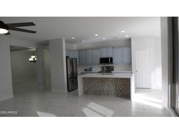 Bright kitchen boasts stainless steel appliances, stylish island, and updated cabinets, perfect for modern living at 29462 N 126Th Ln, Peoria, AZ 85383