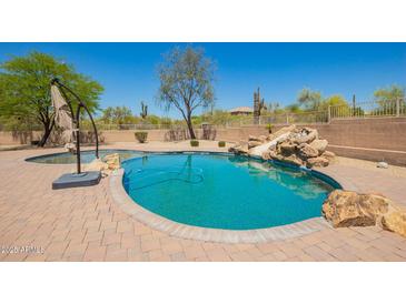 Backyard pool with desert landscaping, brick patio, and slide feature for recreational enjoyment at 32525 N 41St Way, Cave Creek, AZ 85331