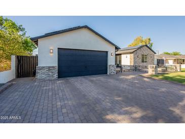 Wide brick driveway leading to a modern home with a spacious two-car garage at 3834 E Clarendon Ave, Phoenix, AZ 85018