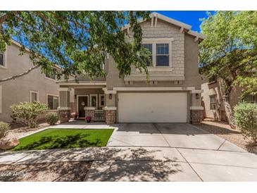 Two-story home with a two-car garage, landscaped front yard with decorative stone and a covered front porch at 4117 E Baylor Ln, Gilbert, AZ 85296