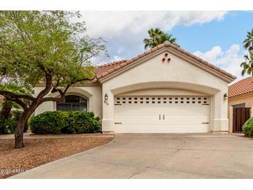 Charming single Gathering home with a wide driveway leading to a large garage and manicured front yard at 4738 N Greenview W Cir, Litchfield Park, AZ 85340