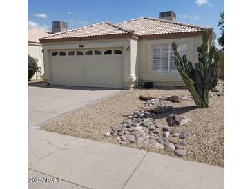 Charming single-story home featuring desert landscaping and a two-car garage at 4765 E Charleston Ave, Phoenix, AZ 85032
