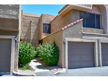 Attractive exterior featuring garage doors, desert landscaping and a walkway at 5122 E Shea Blvd # 1043, Scottsdale, AZ 85254
